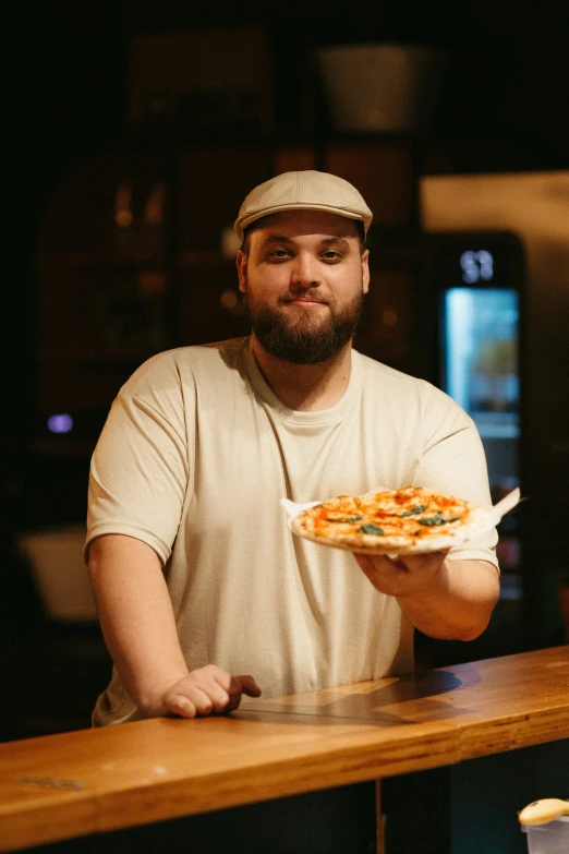 a man holding a pizza in his hand