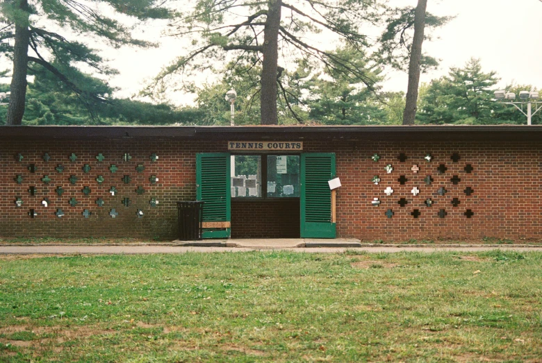 a green door sits at the entrance to an open brick building