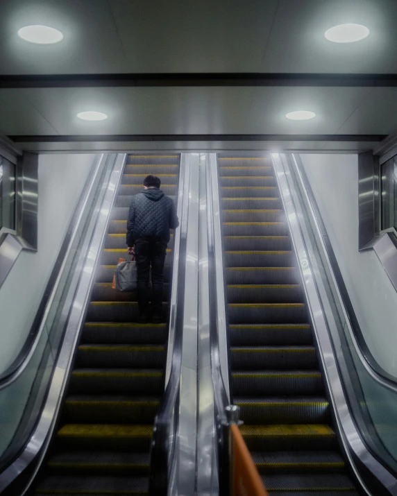 two people walking up an escalator at a city station