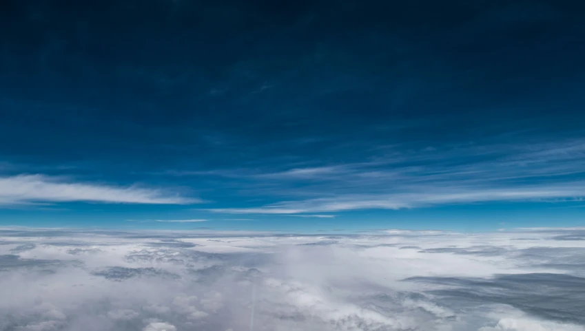 an airplane is flying high above the clouds