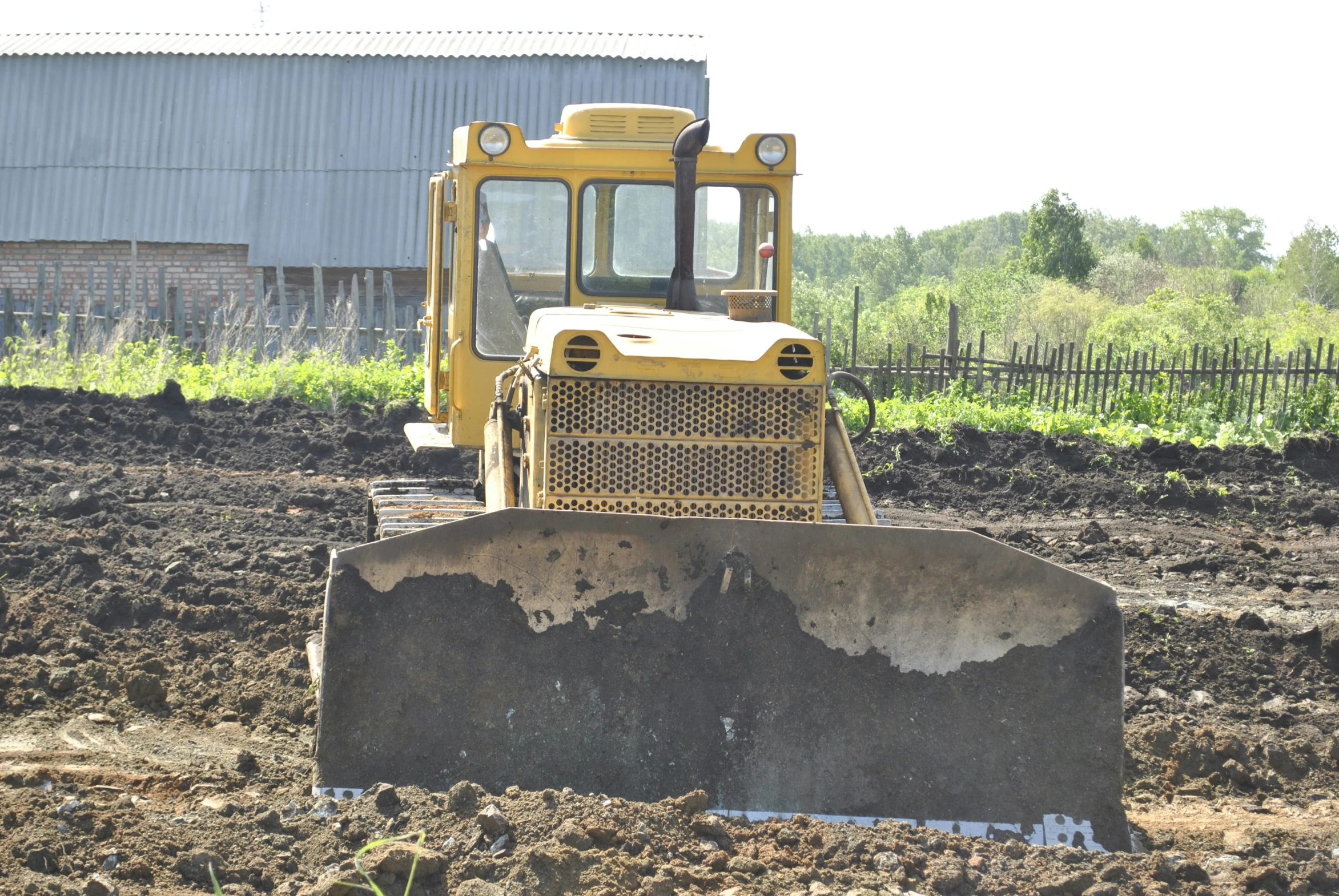 a bulldozer moving earth in front of a building