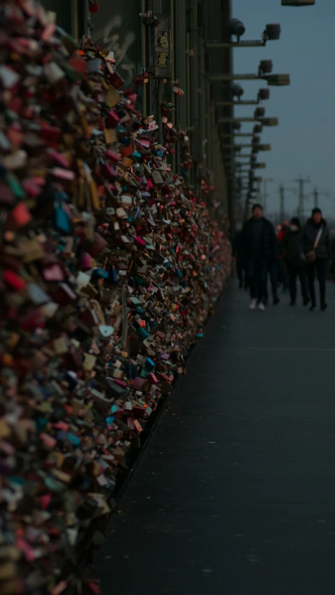 people walking past a wall of locks