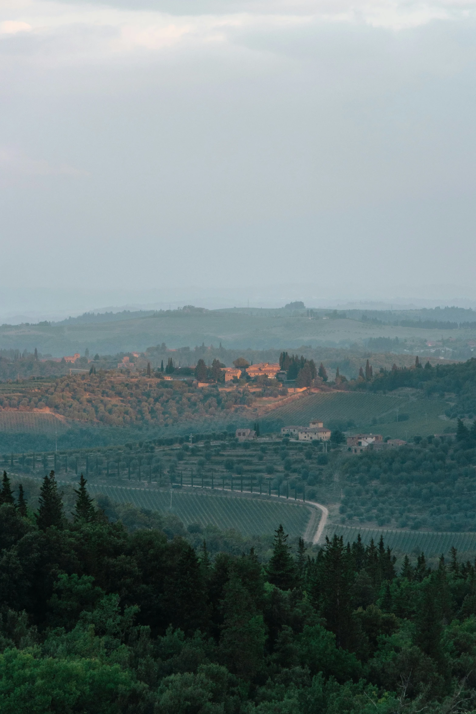 a hill overlooking a valley and a small building in the distance