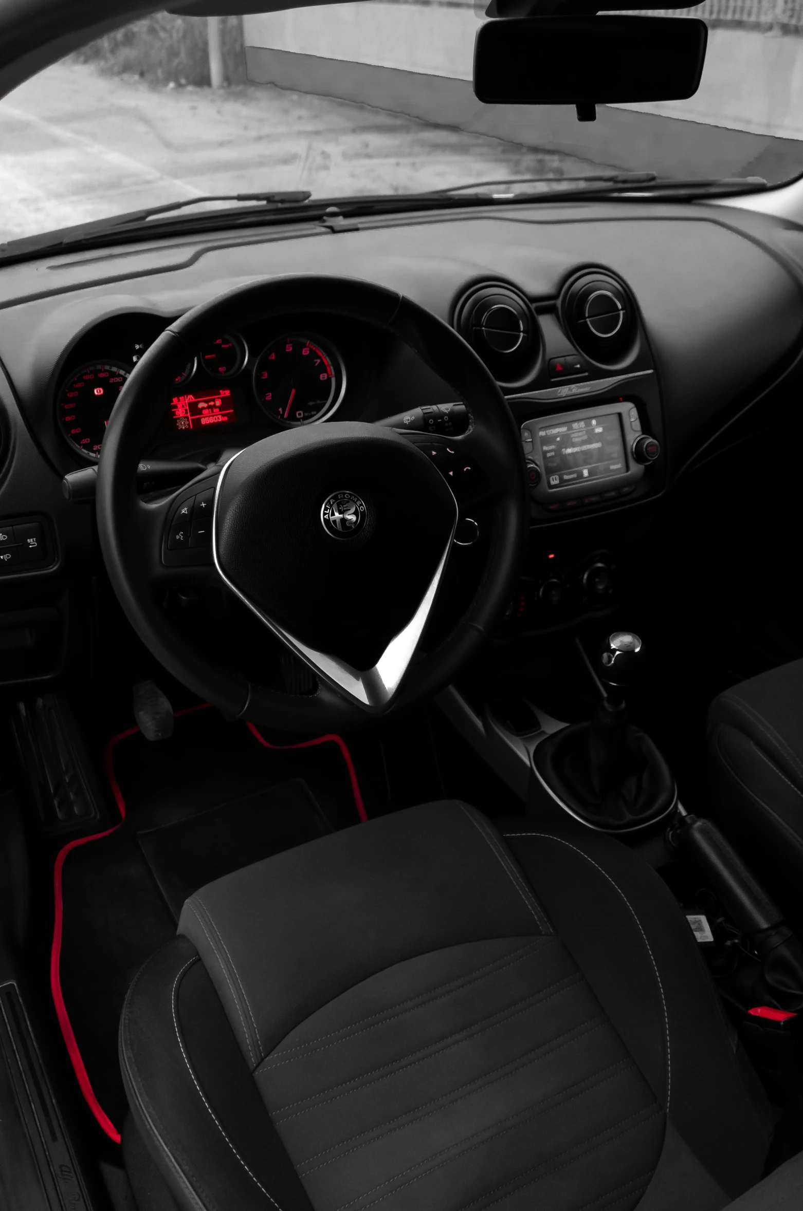 dashboard controls of a modern looking automobile with red accent accents