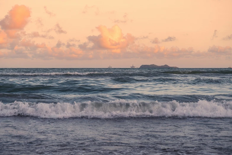 the horizon is shown over the ocean at sunset