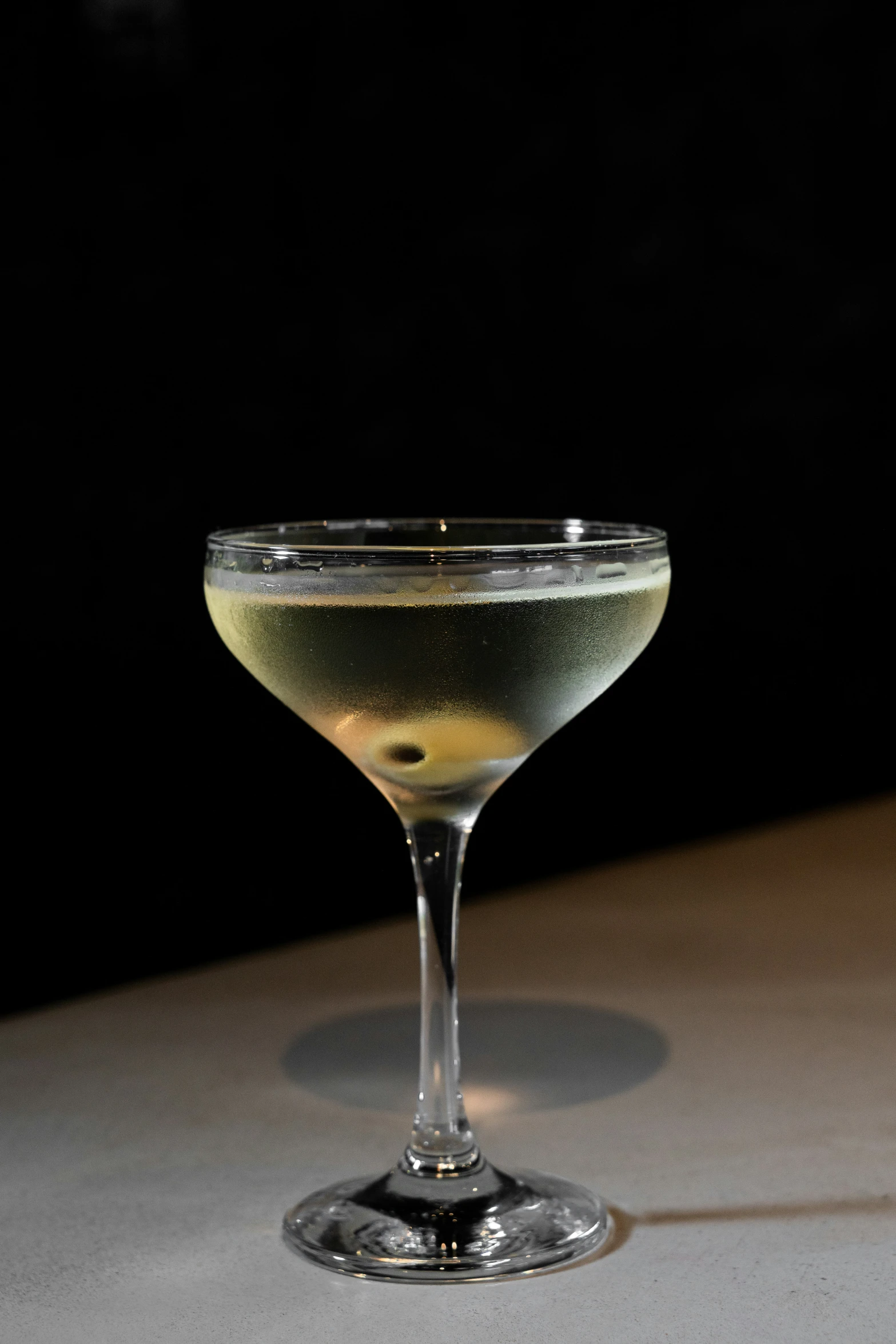 a martini glass with a drink sitting on the table