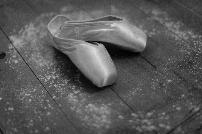 two ballet shoes laying on the floor in black and white