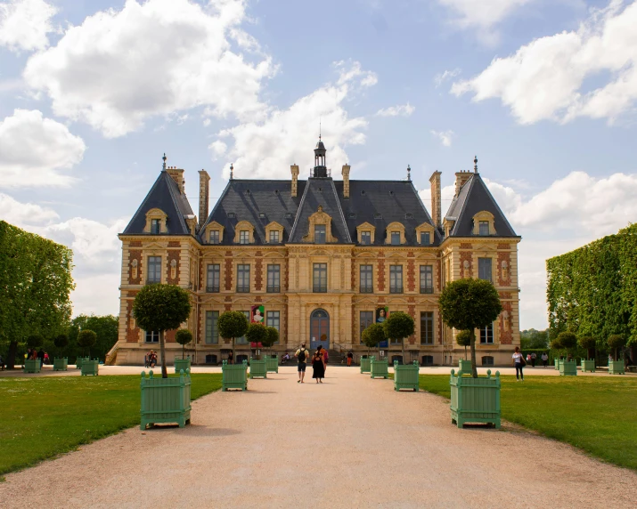 a large stone building in front of a green lawn