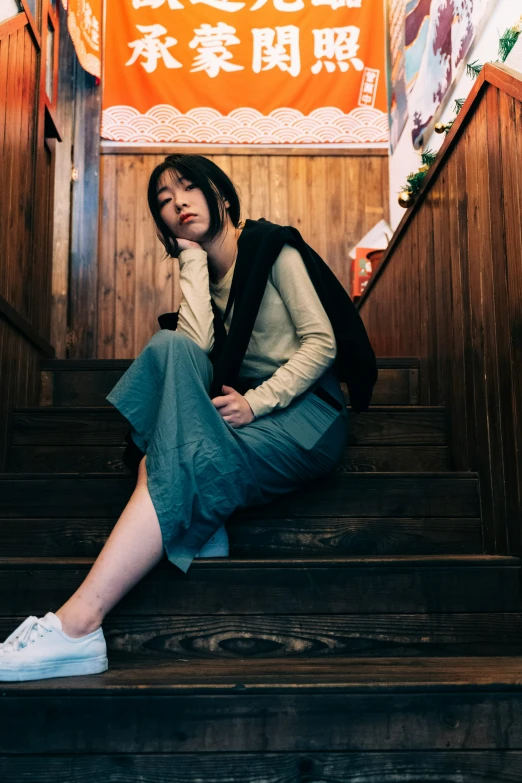 a woman sits on the stairs at an asian restaurant