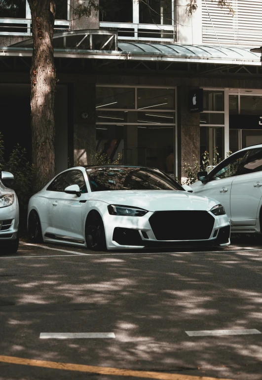 two cars parked on a street by a building