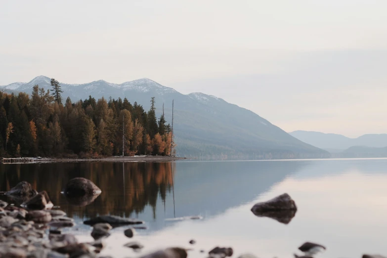 a lone boat sits in the still waters of a mountain lake