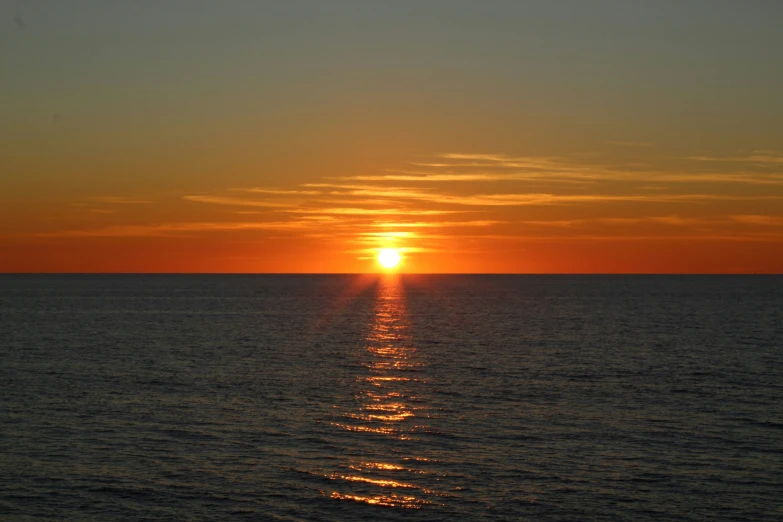 the setting sun shines brightly over the ocean