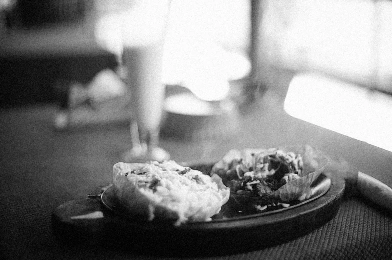 an omelet is sitting next to an empty glass on a plate