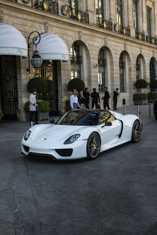 the white sports car is parked in front of the building