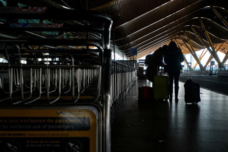 people are pulling luggage towards the platform of the train station