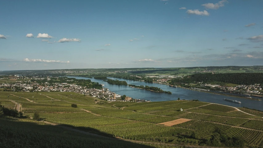 a river surrounded by lush green fields and small village