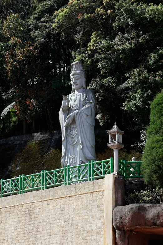 the statue stands tall in front of the trees