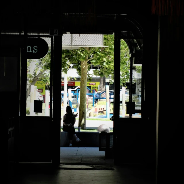 a person sitting on a bench outside a bus stop