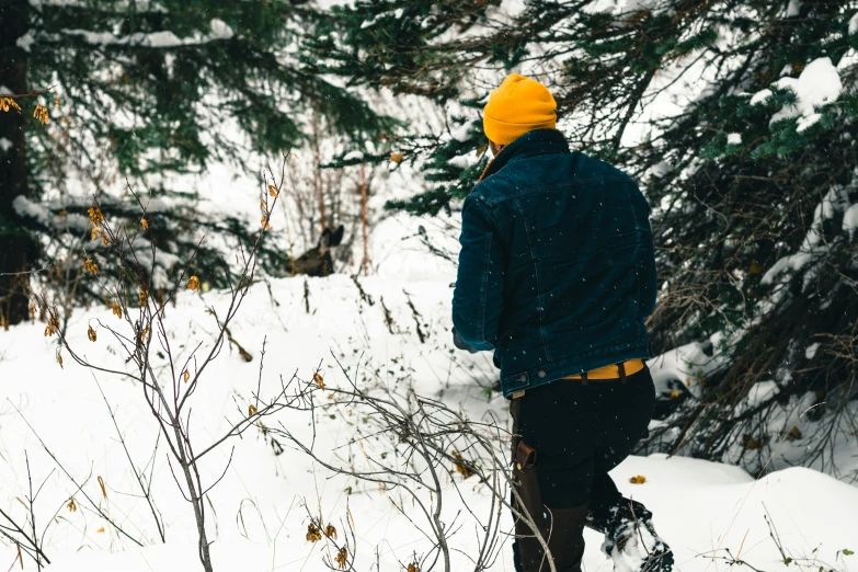 a man walking through the snow with his snowboard