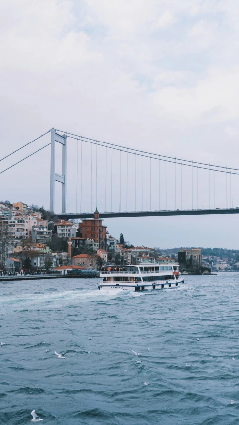 two boats on water next to bridge and city