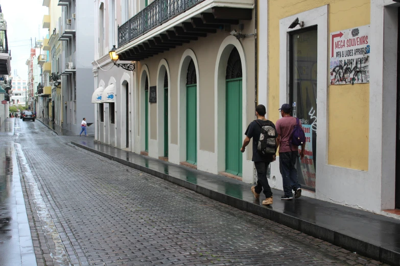 two men standing next to each other near a street