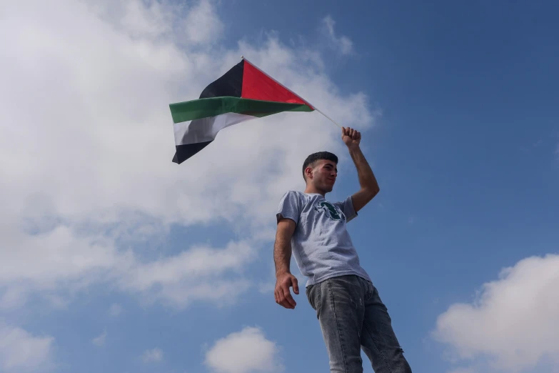 a man in shorts standing on top of a roof holding onto a kite