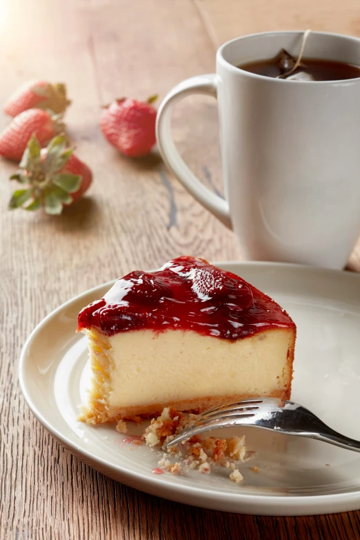 a piece of cheese cake sits on the plate near a cup