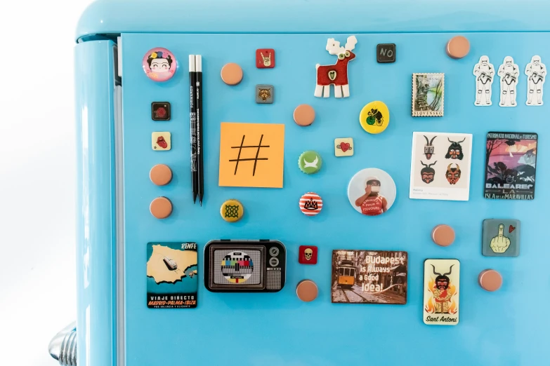 an old fridge with many small magnets on the front