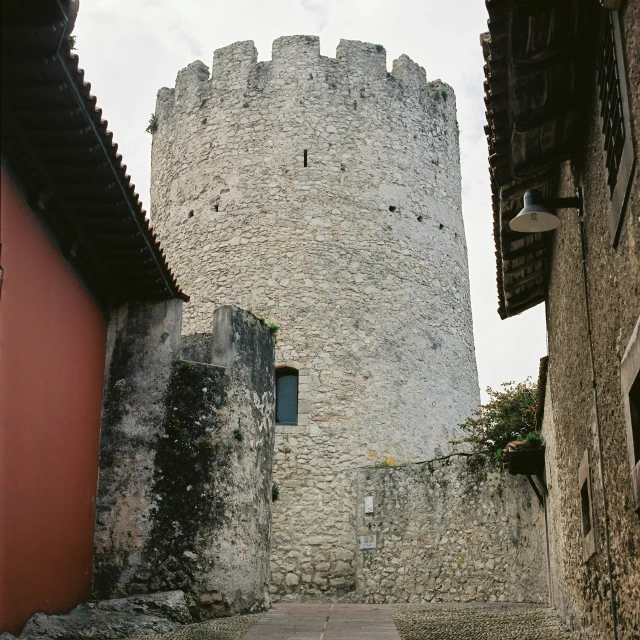 a tower rises above a city street with buildings around it