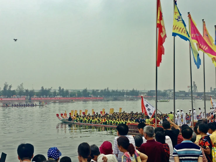 a long rowboat on water with many people standing around