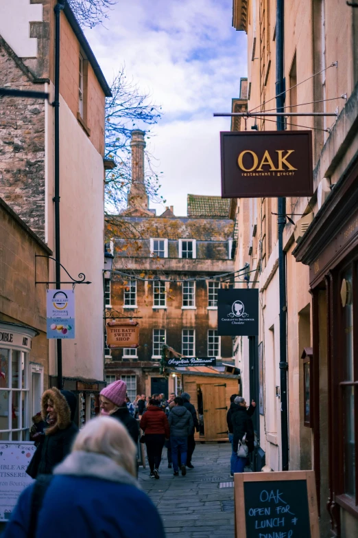 many people walk down the alley near some stores