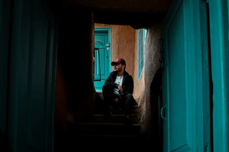 a man sitting on steps looking into a doorway