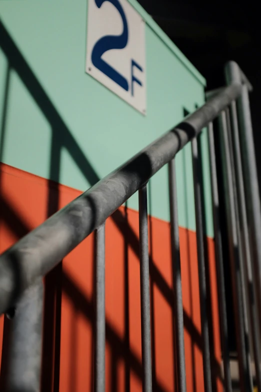 the handrails of a steel fence near a building with two signs