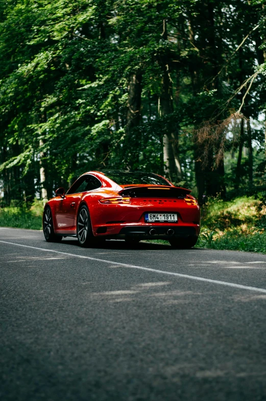 the red sports car is driving down the road