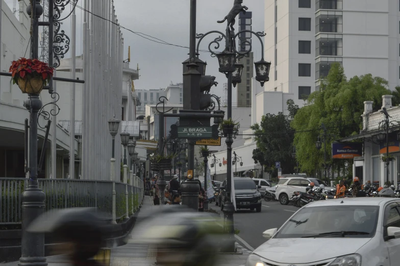 the street has cars parked along both sides and many buildings