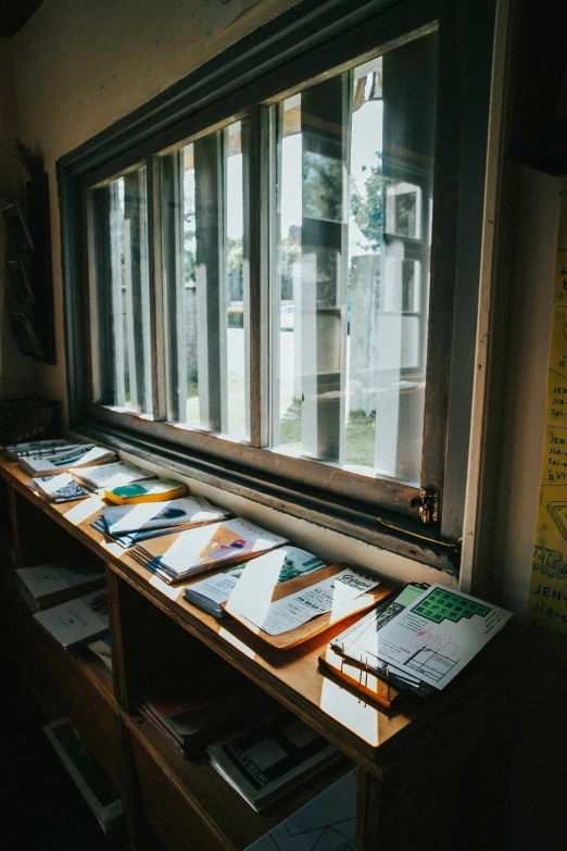 books sit on the shelf beside an open window