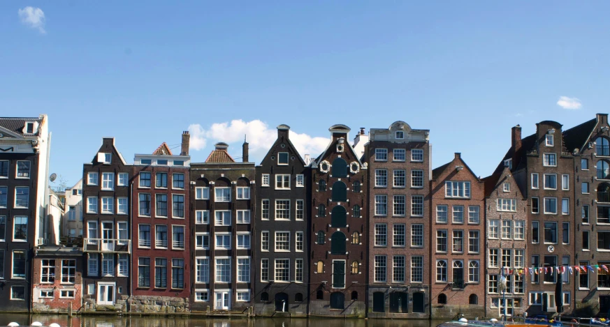 several boats floating on the river in front of large brown buildings