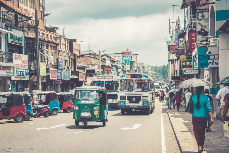 a busy street with many buses and some people