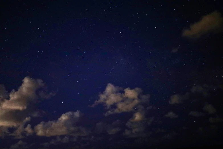 the night sky with stars and clouds is pictured in this image