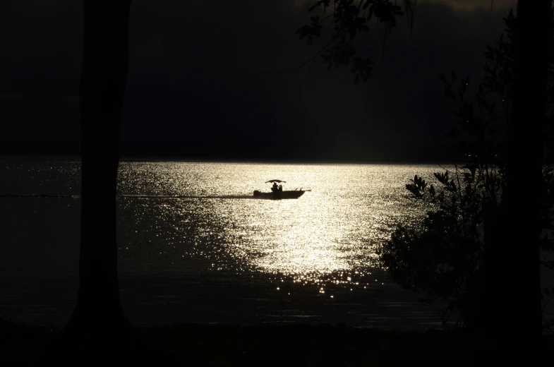 a person on a boat in the water during a dark evening