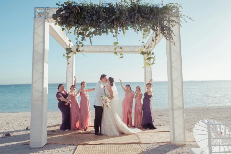 the bride and grooms are posing in front of an outdoor gazebo