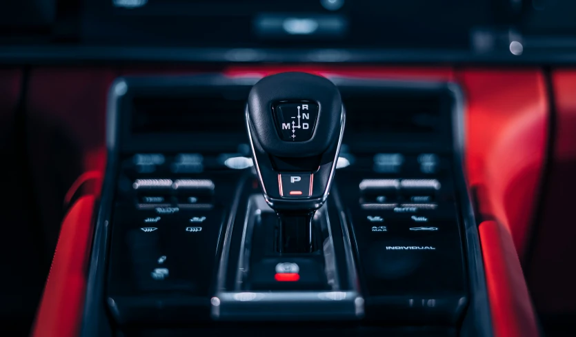 an automobile control panel with a red leather console