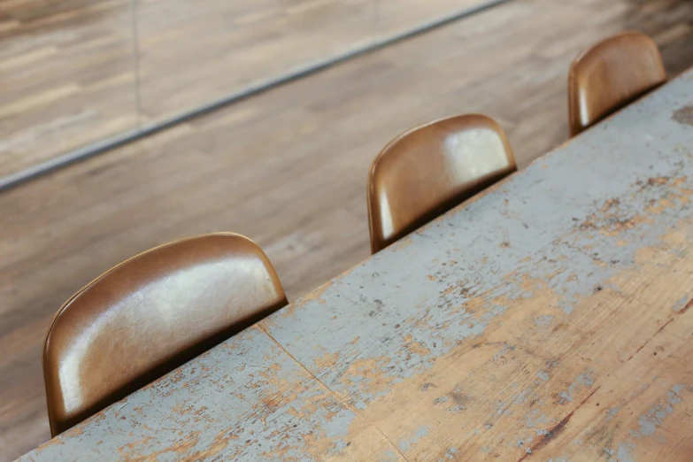 three metal stools are sitting near the wooden table