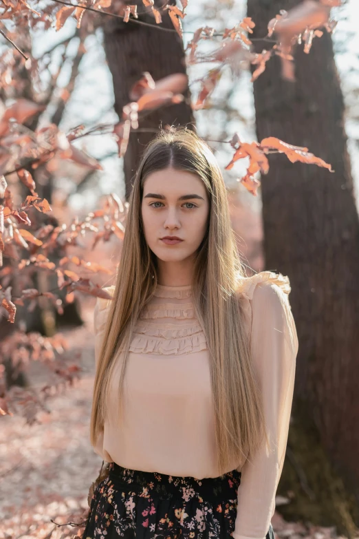 a woman standing near a tree in a forest