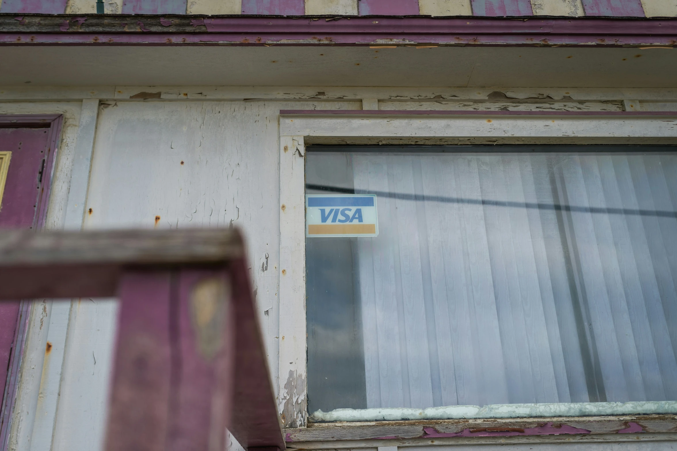 an old window with some sort of sticker hanging on it