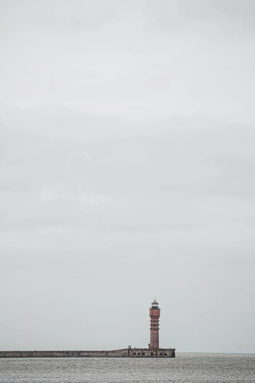 the lighthouse sits atop a rocky island in the middle of the ocean