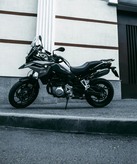 motorcycle parked on concrete in front of tall building