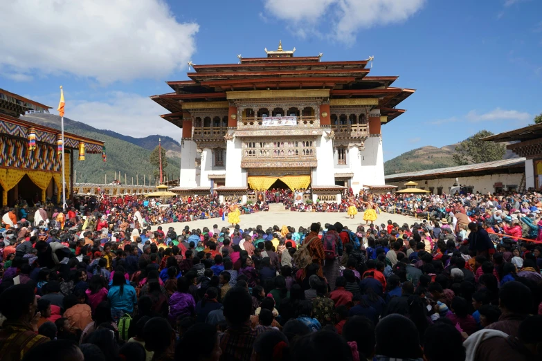 an open area filled with people and two colorful buildings in the background