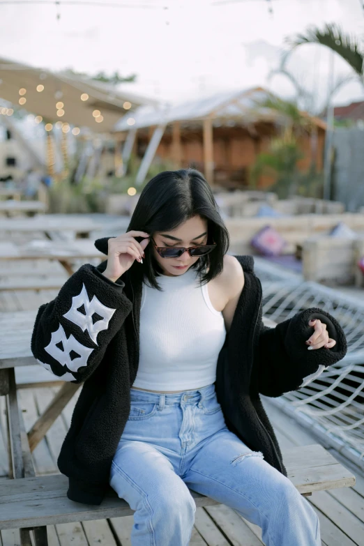 a beautiful woman in white top sitting on a bench