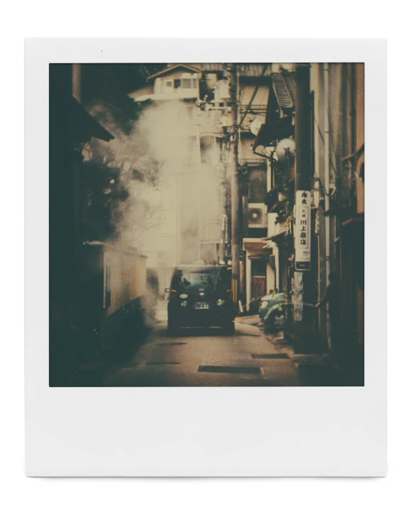 a narrow alleyway with factories smoke billowing